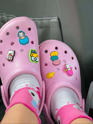 粉紅色Crocs鞋，帶卡通吊飾和相配襪子，在汽車座椅上。 — Crocs 壁紙