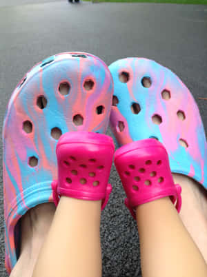 腳穿彩色紮染Crocs涼鞋在人行道上。 — Crocs 壁紙