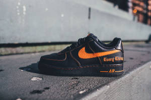黑色Nike Air Force 1運動鞋，在混凝土人行道上帶有橙色細節 — Vlone 壁紙