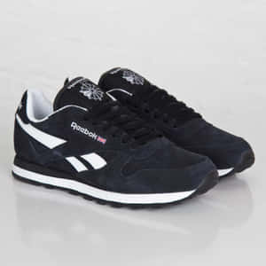 黑色麂皮Reebok運動鞋，帶有白色條紋和英國國旗，在反光白色背景上。 — 銳步 壁紙
