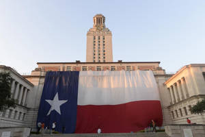 日落時分，德州州旗鋪在大學階梯上。 — 德克薩斯州旗 壁紙