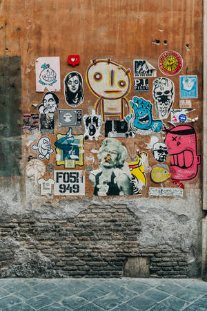 小巷中覆蓋著層層塗鴉貼紙和海報的牆壁。 — 街頭藝術 壁紙