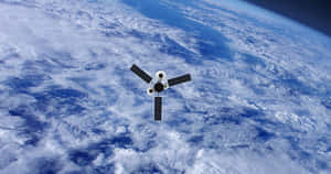 衛星漂浮在地球被雲層覆蓋的表面上方。 — 宇宙 壁紙
