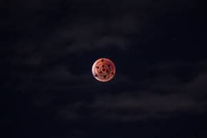 星空夜空中帶有黑色螺旋符號的紅色月亮