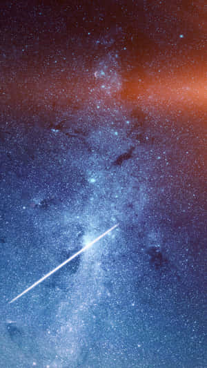 一顆明亮的流星在色彩繽紛的星空星系中留下軌跡，帶有藍色和橙色調。 — 美學藍色 iPhone 壁紙