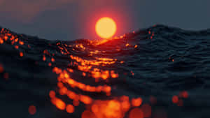 海上日落，黑暗波浪上反射出發光的橙色光芒。 — 海灘日落 壁紙