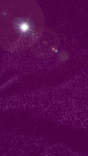 一顆明亮的星星，在紫色宇宙場域中帶有鏡頭光暈和閃爍粒子。 — 低對比 壁紙