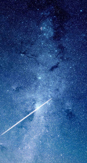 一顆明亮的流星在繁星點點的藍色夜空中留下軌跡，伴隨著星雲和一彎新月。 — 藍色銀河 壁紙