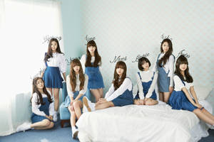 七位身穿白色襯衫和藍色連身褲的K-pop女孩在臥室裡擺姿勢。 — 오마이걸 壁紙