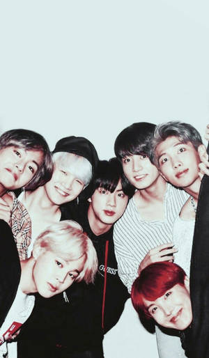 七位擁有色彩繽紛頭髮的年輕男子在團體照中緊密地擺姿勢。 — BTS 壁紙