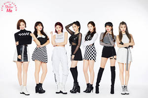 七位K-pop女孩穿著黑白格紋服裝在攝影棚擺姿勢。