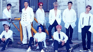 七位時尚男士身穿白色服裝，在城市工業環境中擺姿勢。 — Super Junior 壁紙