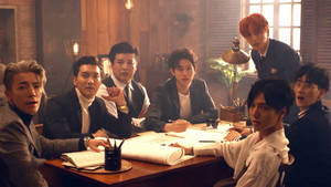 七個穿西裝的男人在辦公室木桌旁顯得驚訝。 — Super Junior 壁紙