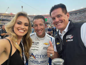 三位微笑的NASCAR人士在賽道上擺姿勢自拍。 — 讚 壁紙