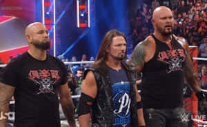 三位WWE摔角手在現場活動中站在擂台上，背景有粉絲。 — 摔角 壁紙