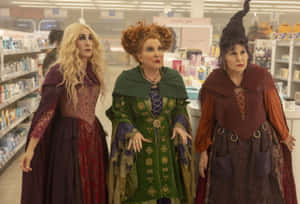 三位身穿色彩繽紛服裝的女巫站在商店通道中。 — Hocus pocus 壁紙