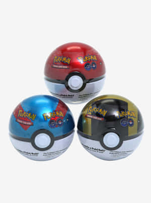 三個紅色、藍色和黑金色的 Pokémon GO 寶可夢球玩具。 — iPad 第9代 壁紙