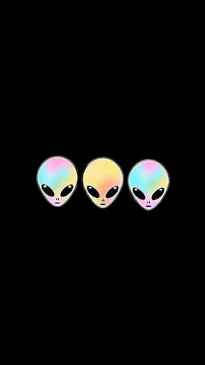 三個卡通外星人頭顱，在黑色背景上呈現彩虹色虹彩皮膚 — 太空人美學 壁紙