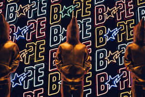 三個戴帽人物面向霓虹燈照亮的Bape標誌牆。 — Bape 動態 壁紙
