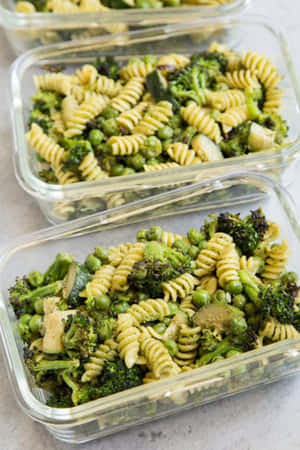 三個玻璃容器裝有綠色義大利麵、青花菜、豌豆和櫛瓜的備餐。 — 蔬菜 壁紙