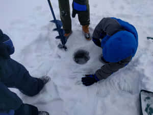 三個人正在雪中鑽孔進行冰釣。 — 可愛的雪 壁紙