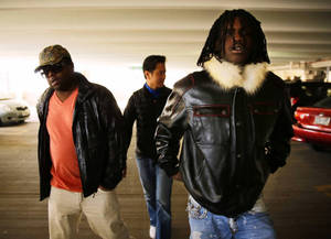 三個穿著皮夾克的男人在夜間穿過停車場。 — Chief Keef 壁紙