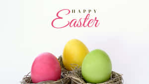 三個粉彩復活節彩蛋在巢中，帶有 'Happy Easter' 文字。 — 春天 壁紙