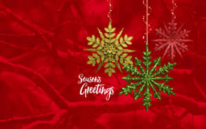 三個懸掛的閃閃發光雪花裝飾品，置於紅色雪白樹枝上，附有 Seasons Greetings 文字。 — 慶祝 壁紙