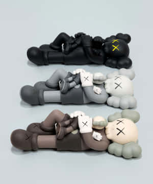 三個黑色、灰色和棕色的KAWS Companion公仔堆疊，帶有X形眼睛和雲朵頭部。 — Motorola Razr Ultra 2025 壁紙