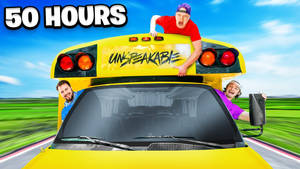 三名男子在一輛高速行駛的黃色校車上大笑，車上有「UNBREAKABLE」塗鴉。 — 縮圖 壁紙