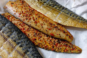 烤鯖魚柳以紅辣椒片和芝麻調味，放在烘焙紙上。 — 魚 GIF 壁紙