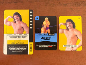 三張 Rick Rude 的 WWE 收藏卡放在木桌上。 — 運動 壁紙