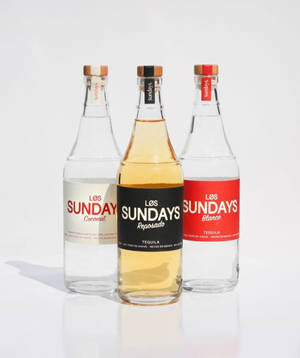 三款不同口味的 Los Sundays 龍舌蘭酒瓶展示在白色表面上。 — Motorola Razr Ultra 2025 壁紙