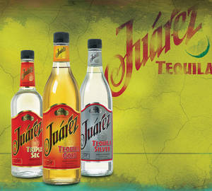 三瓶 Juárez 龍舌蘭酒放在有裂紋的黃綠色背景上，帶有品牌標誌。 — 瓜達拉哈拉 壁紙