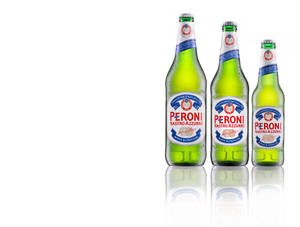 三瓶Peroni啤酒瓶帶有水珠，放在白色反射表面上。 — 啤酒 壁紙