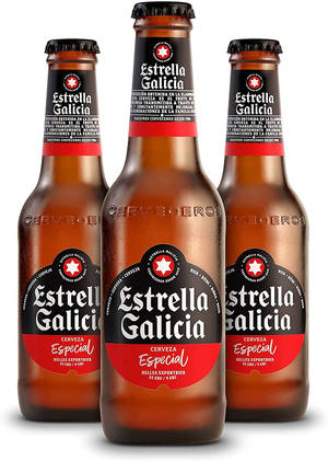 三瓶Estrella Galicia啤酒瓶在白色背景上排列成一排。 — 啤酒 壁紙