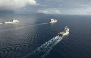 三艘戰艦在公海編隊航行，可見尾跡和遠處陸地。 — 珍珠港 壁紙