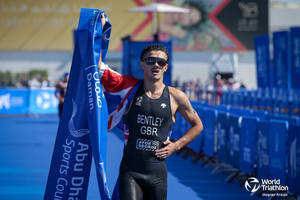 三項鐵人運動員 Bentley GBR 在阿布達比世界三項鐵人賽中手持旗幟和橫幅慶祝勝利。 — 運動 壁紙