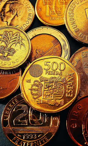 一堆具有精細雕刻和不同面值的國際硬幣。 — 金色動態 壁紙