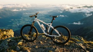 一輛白色登山車佇立於山頂，俯瞰令人屏息的山谷美景。 — 登山車 壁紙