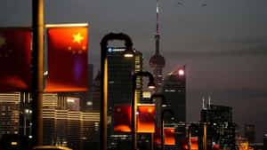 中國國旗在黃昏時分照亮上海閃爍的摩天大樓。 — 城市風景 壁紙