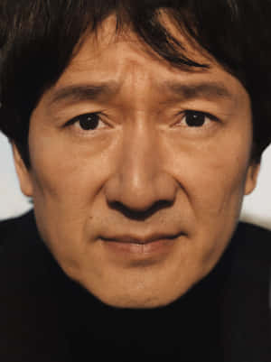平靜的中年男子特寫肖像，有深色頭髮和溫暖燈光。 — 凱羅·忍 壁紙