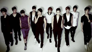 九位時尚男士身穿黑色和白色服裝在攝影棚中擺姿勢。 — Super Junior 壁紙