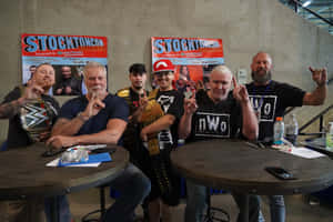 WWE摔角手與粉絲在斯托克頓的簽名活動中手持冠軍腰帶擺姿勢。 — 吉米·巴特勒 壁紙
