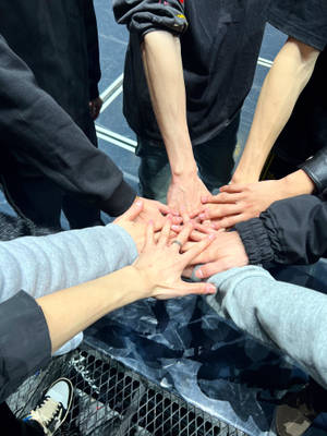 五隻手疊成一個圓圈，展現團結和團隊合作。