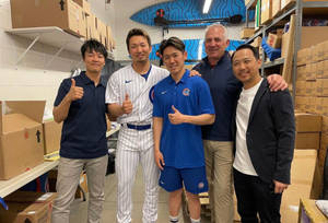 五個穿著棒球制服和休閒服的男人在倉庫中開心地擺姿勢。 — 運動 壁紙