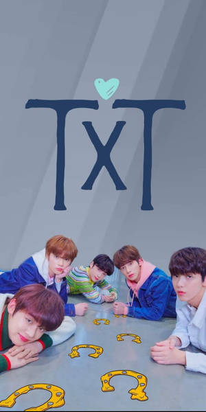 五個K-pop偶像在帶有愛心的TXT標誌下圍繞馬蹄鐵擺姿勢。