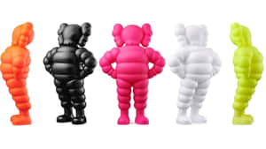 五個KAWS Companion公仔，分別是橙色、黑色、粉紅色、白色和萊姆綠色，排成一列。 — 三島一八 壁紙