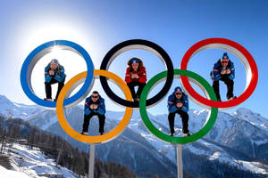 五名運動員在白雪覆蓋的山上於奧運五環內擺姿勢。 — 奧運 壁紙