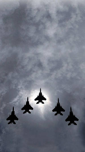 五架戰鬥機在多雲天空中以編隊飛行，太陽在背後。 — 航太 壁紙